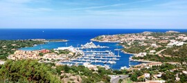 Marina de Porto Cervo, collines vertes et océan en arrière-plan.