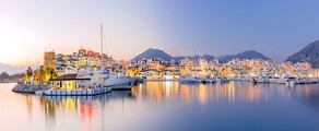 Marina de Puerto Banus au crépuscule, yachts amarrés, toile de fond de montagne.