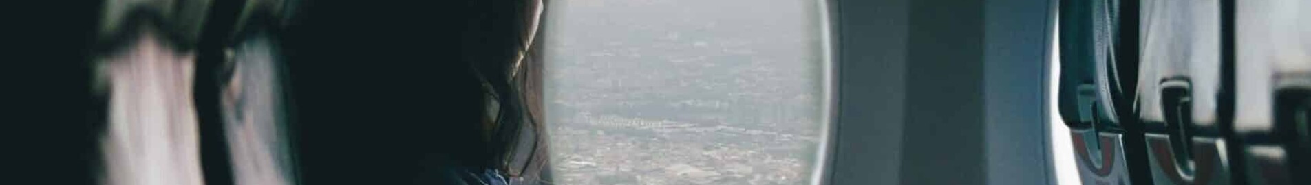 location de jet privé : personne seule regardant par la fenêtre.